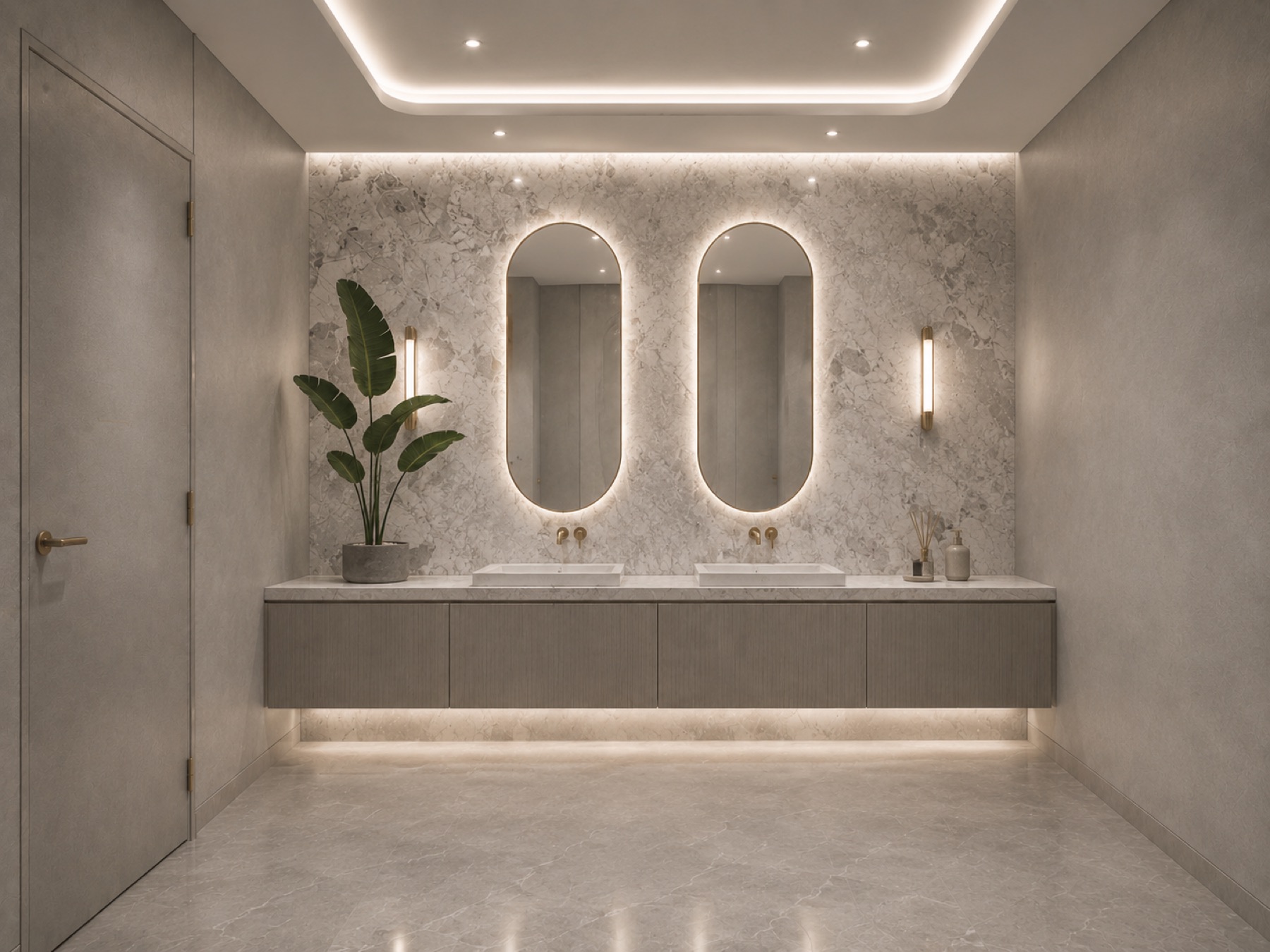 The vanity room — twin oval mirrors haloed in light against bookmatched marble, brass taps below